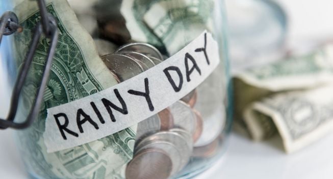 A savings jar of money labeled RAINY DAY