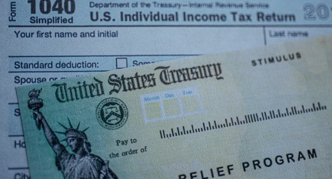 Form 1040 U.S. Individual Income tax return next to the Stimulus Check Relief program. Close up view.