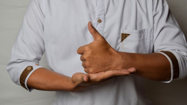 Close up Asian man shows hand gestures it means HELP isolated on white background. American sign language