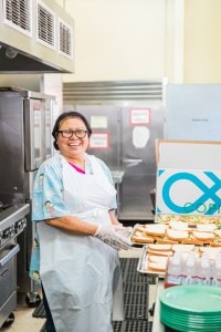 Woman packaging unused food to distribute with Copia