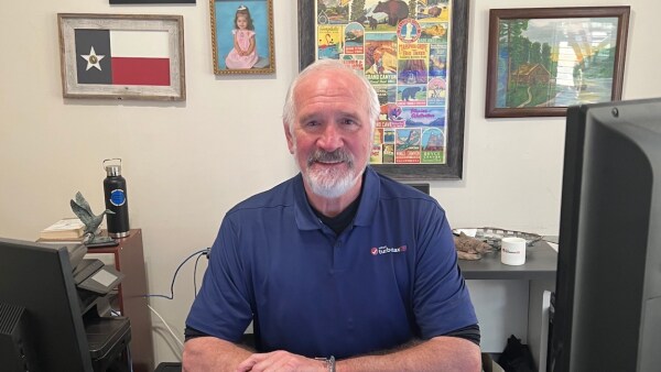 Kent Abney, Intuit tax expert looking at the camera from his desk at home and smiling