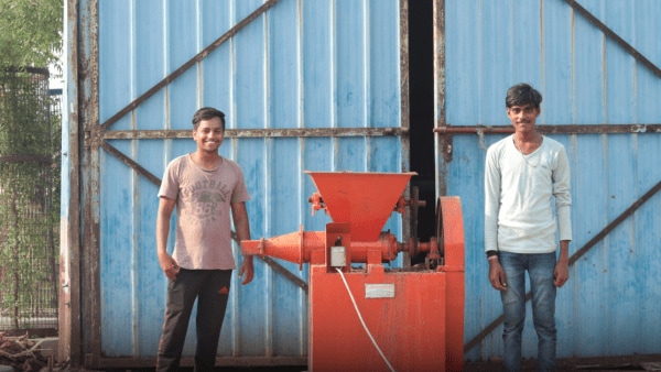 Two students in India smile in front of the camera