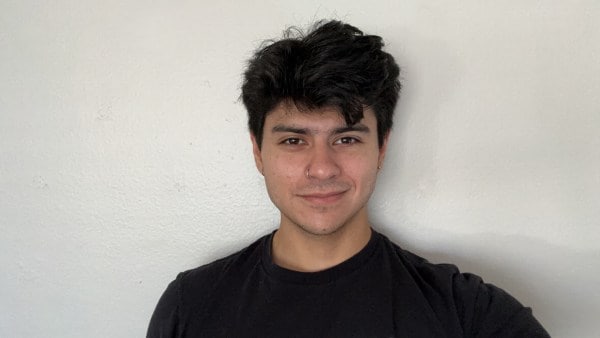 German Flores, an Intuit software engineer smiles for the camera against a white background