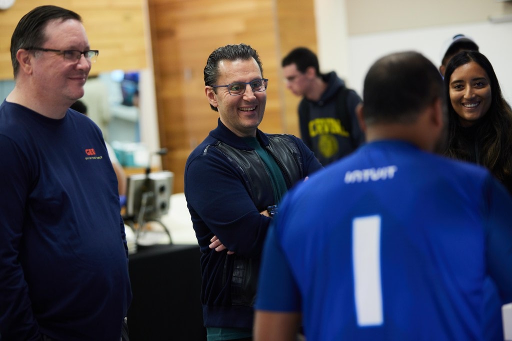 Intuit CEO Sasan Goodarzi smiles while listening to technologists pitch ideas during GED. 