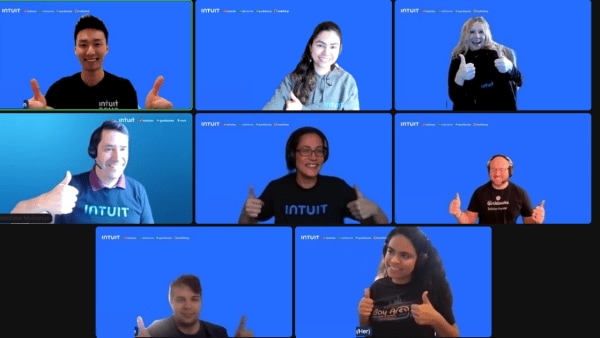 A screenshot of 9 employees from a Zoom call with blue backgrounds giving a thumbs up.