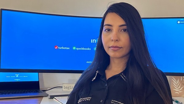 Headshot of brunette-haired woman with Intuit computer in the background.