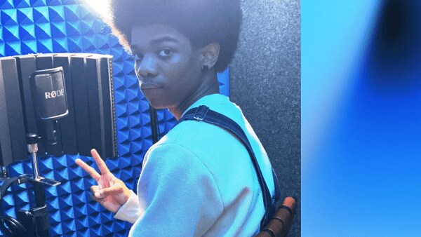 Boy in soundbooth with blue light and recording equipment