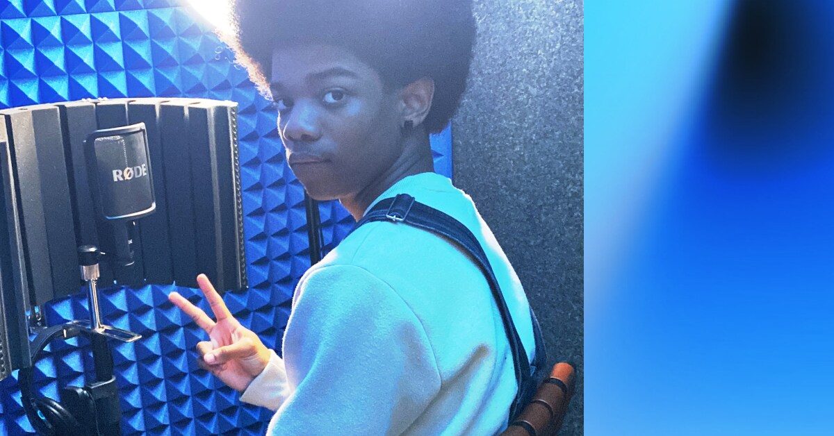 Boy in soundbooth with blue light and recording equipment