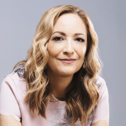 A headshot of Beatriz Acevedo in front of a gray background.