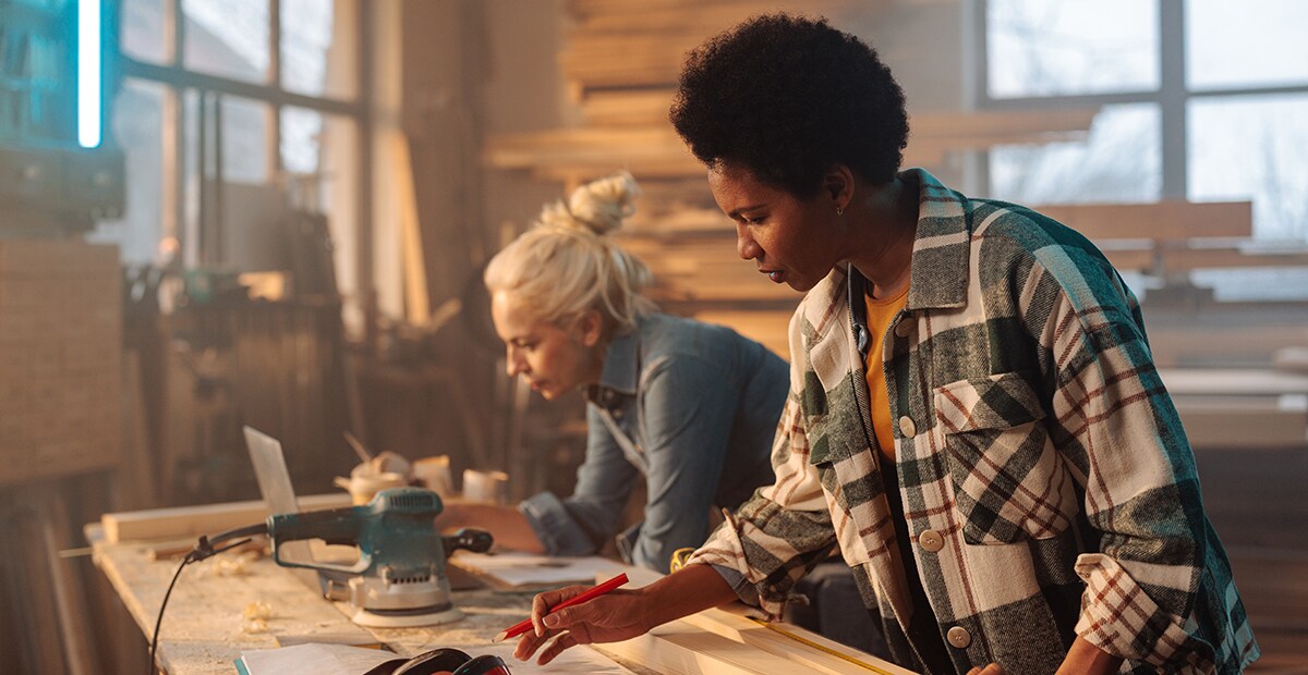 Two women working on a table together.