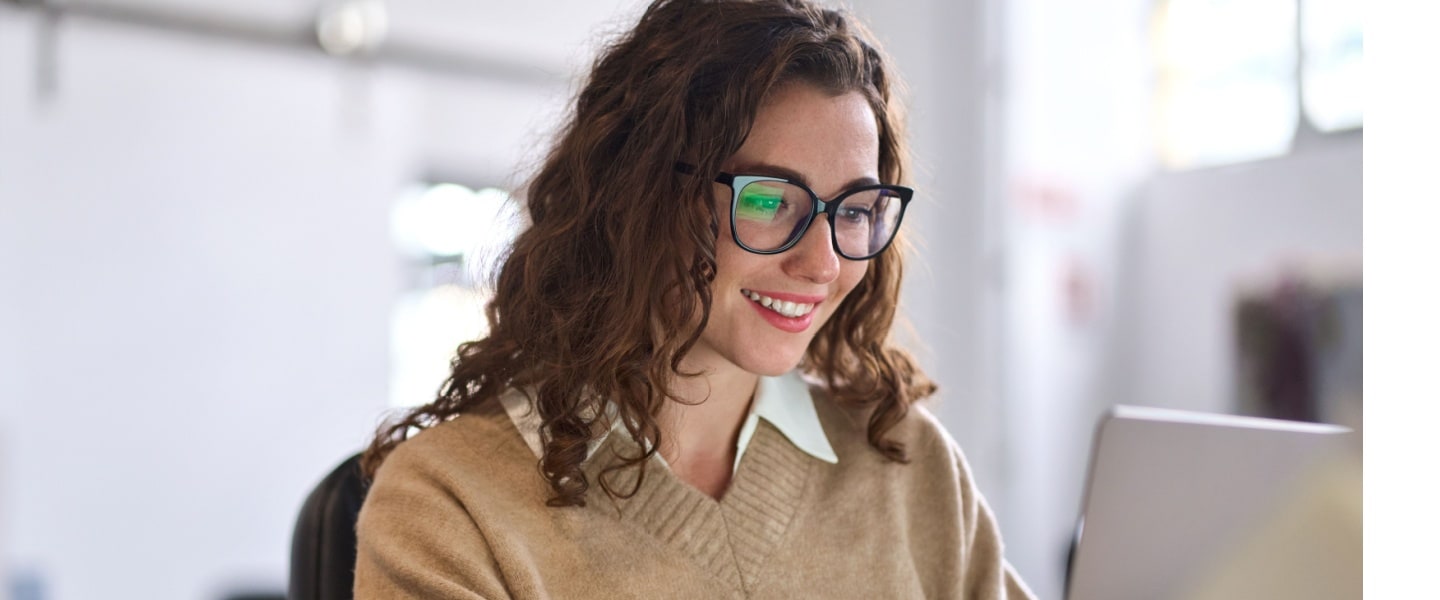 Young happy professional business woman worker employee sitting at desk working