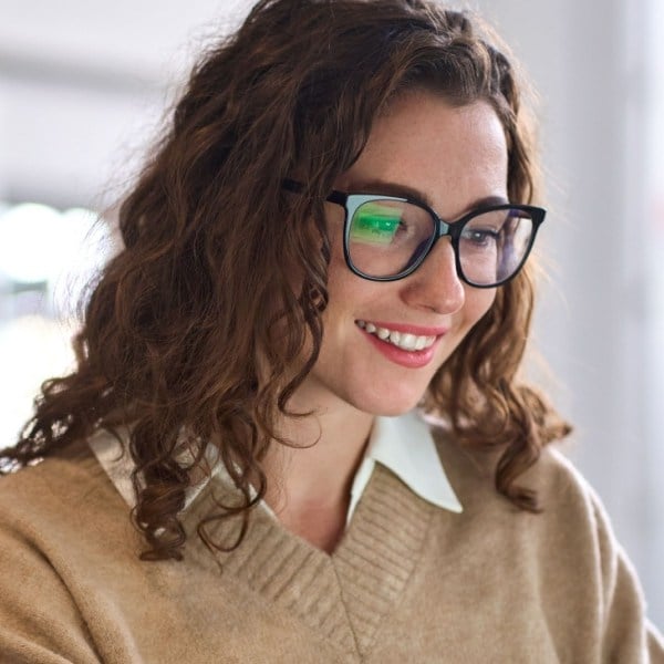 Young happy professional business woman worker employee sitting at desk working