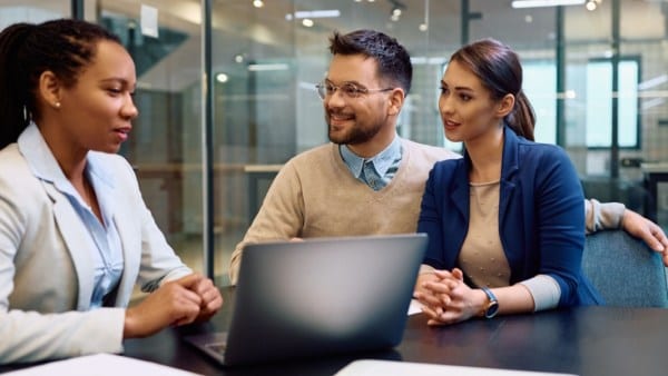 Happy man and his wife getting financial counseling with their advisor in the office