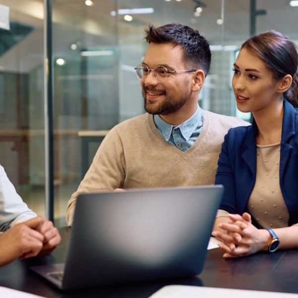 Happy man and his wife getting financial counseling with their advisor in the office