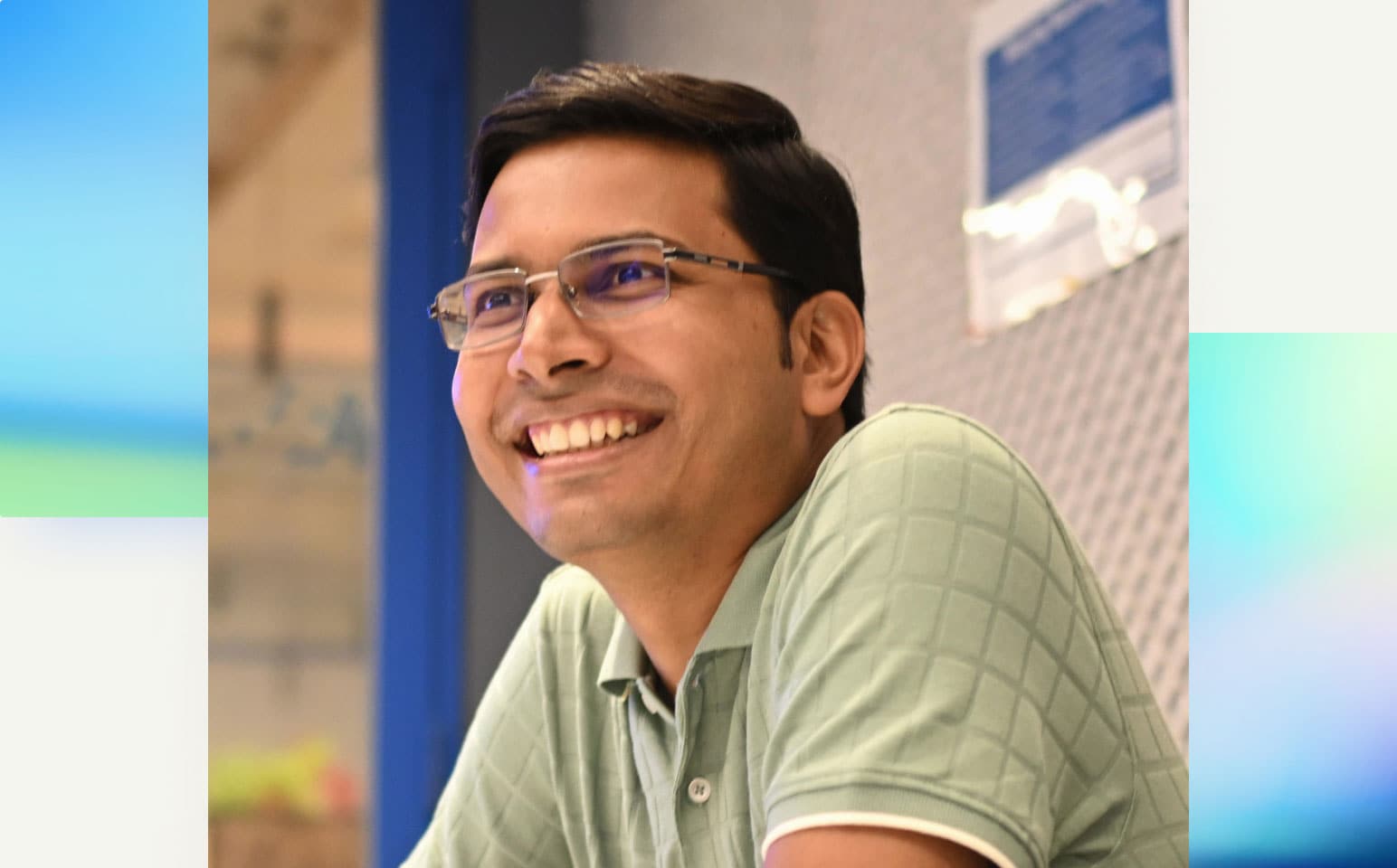 A smiling person wearing glasses and a shirt and tie.
