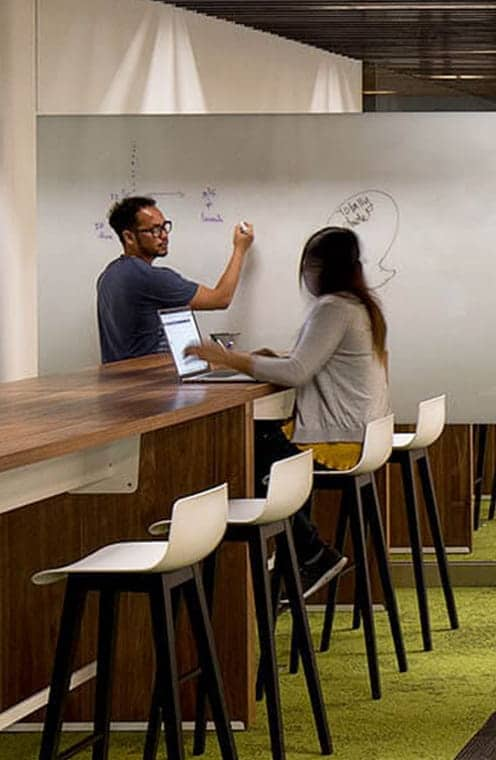 2 people chatting and writing on whiteboard