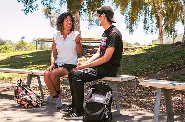 Students talking on a bench at a park