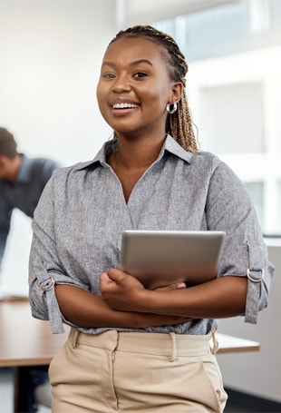 A person is smiling while holding a tablet.