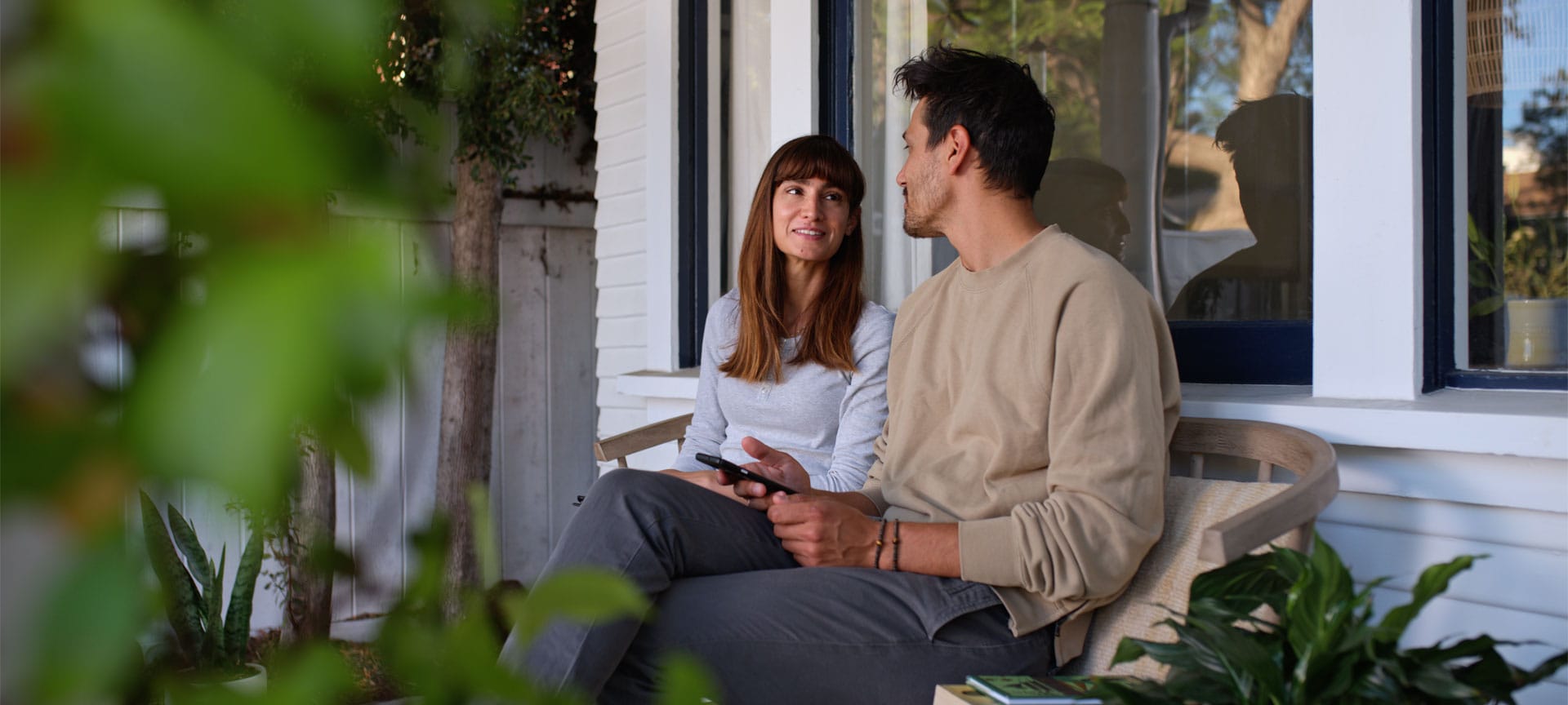 Couple sitting on a bench in front of a house