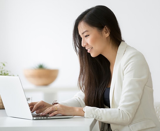 An Intuit Expert, sitting at her home computer, smiling. 