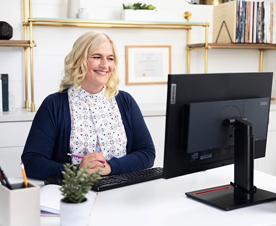 An Intuit Expert, sitting at her home computer, smiling. 