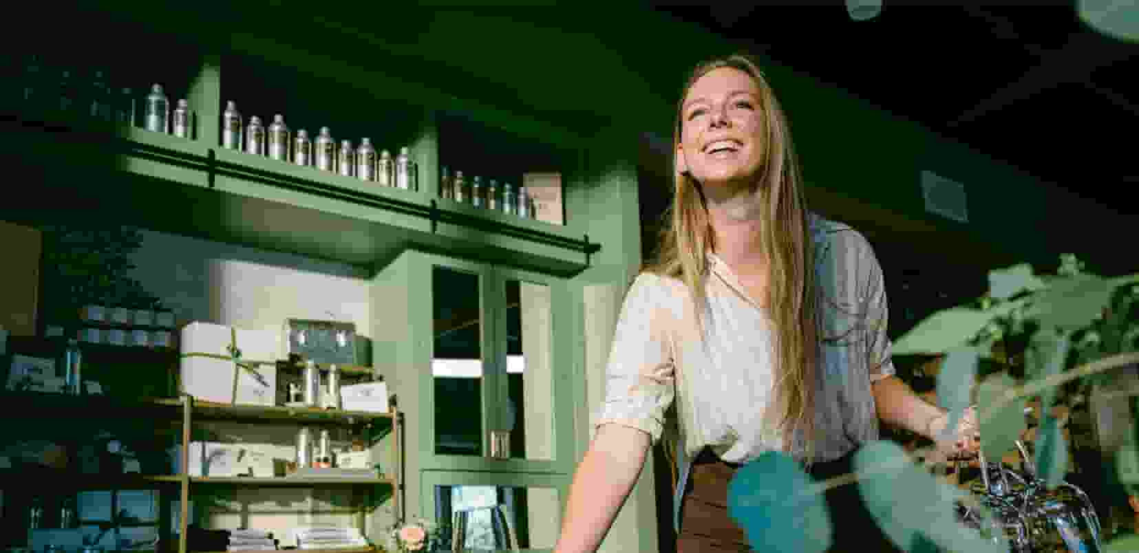 A person standing in a kitchen with a glass cup.