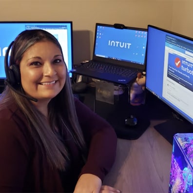 A person sitting at a desk with two computer monitors.