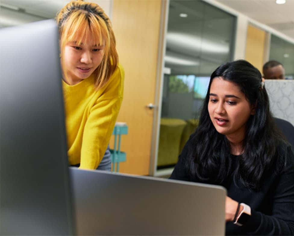 Two Intuit employees talking in front of a computer