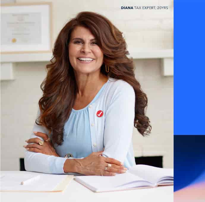 Diana, Intuit Expert for 20 Years, sitting on her desk and smiling. 