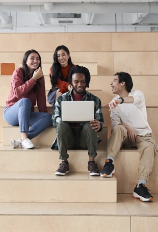 A group of people sitting on top of a wooden bench.