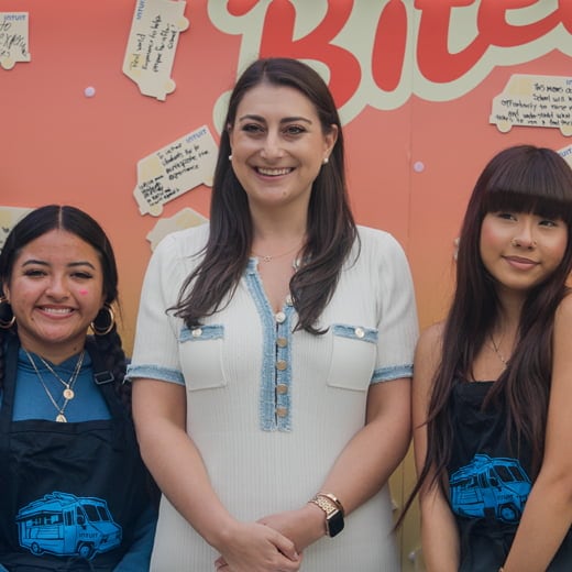 Three people standing in front of a store.