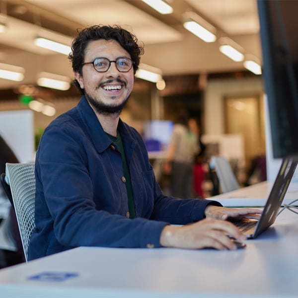 A person sitting at a desk with a laptop computer.