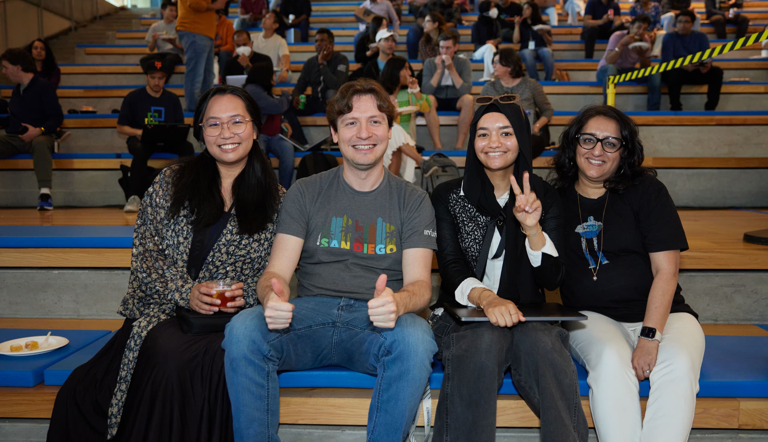 A group of people sitting on top of a wooden bench.