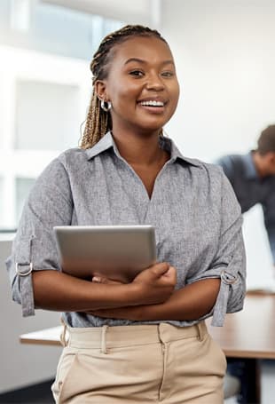 A person is smiling while holding a tablet.