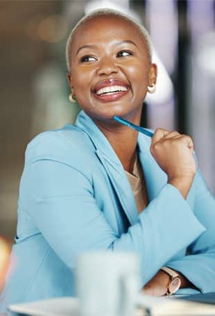 A person smiling and holding a pen.