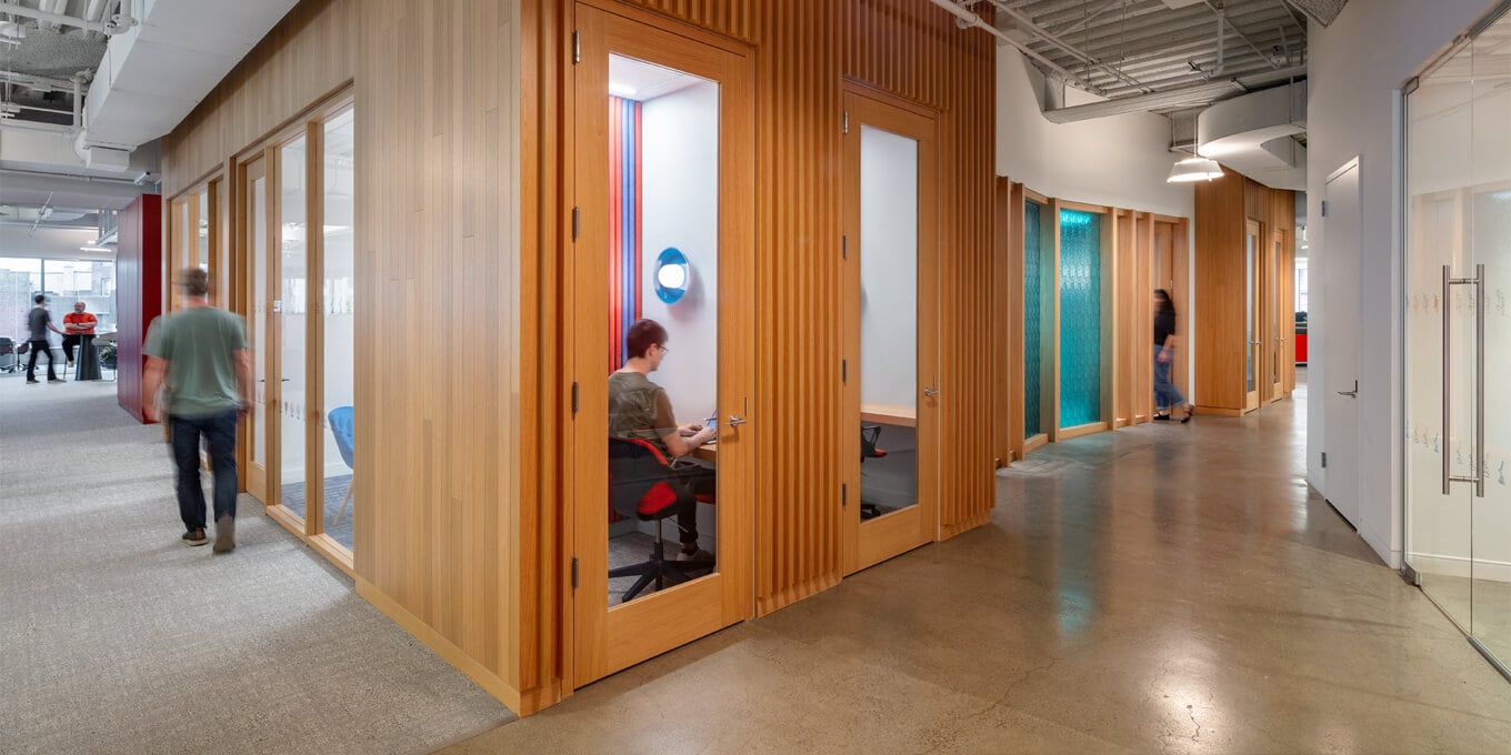 A person and a person in a hallway with a clock.