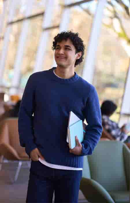 A person in a blue shirt holding a book.