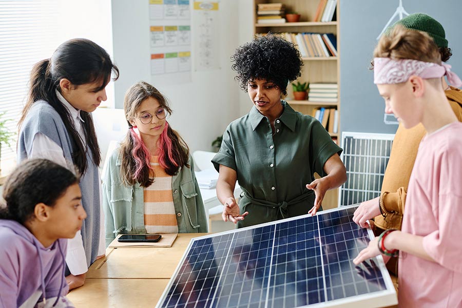 African American teacher talking about solar panel to students during lesson at school