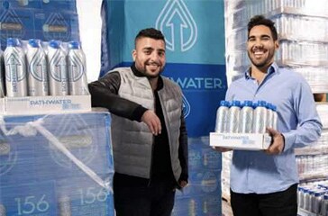 Two people standing next to each other holding a box.