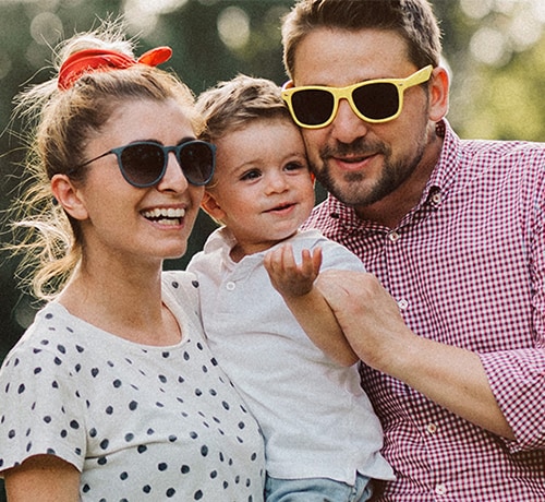 Young family wearing sunglasses, smiling 
