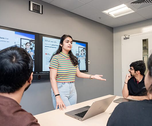 A person standing in front of a laptop computer.