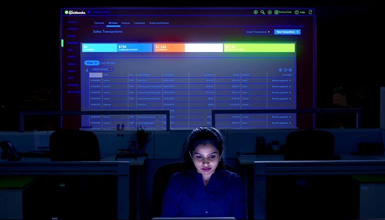 Image Title A woman in front of her laptop writing code for QuickBooks