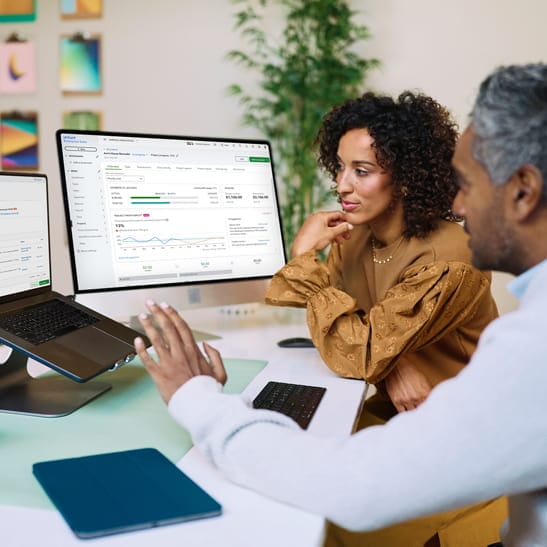 Two people sitting in front of computer