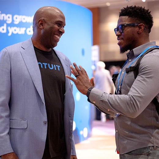 Two people standing next to each other talking.