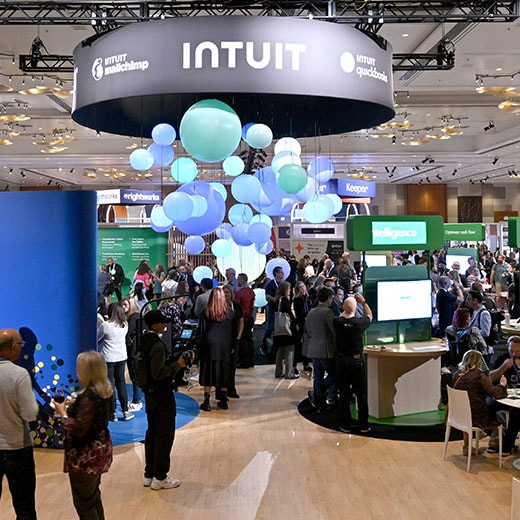A crowd of people standing around a room filled with computers.