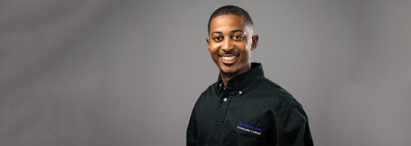 A man wearing a Hillsborough Community College shirt smiling for a photo