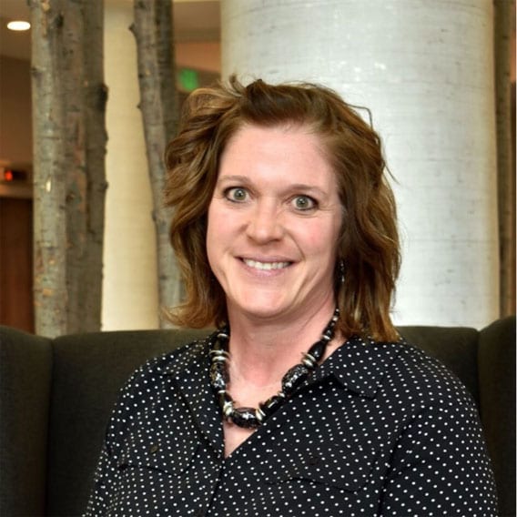 Woman sitting on a couch smiling.