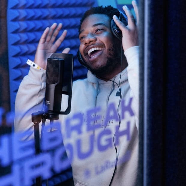 LaRussell in a studio booth making music. 