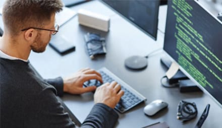 A person sitting at a desk with a laptop computer.