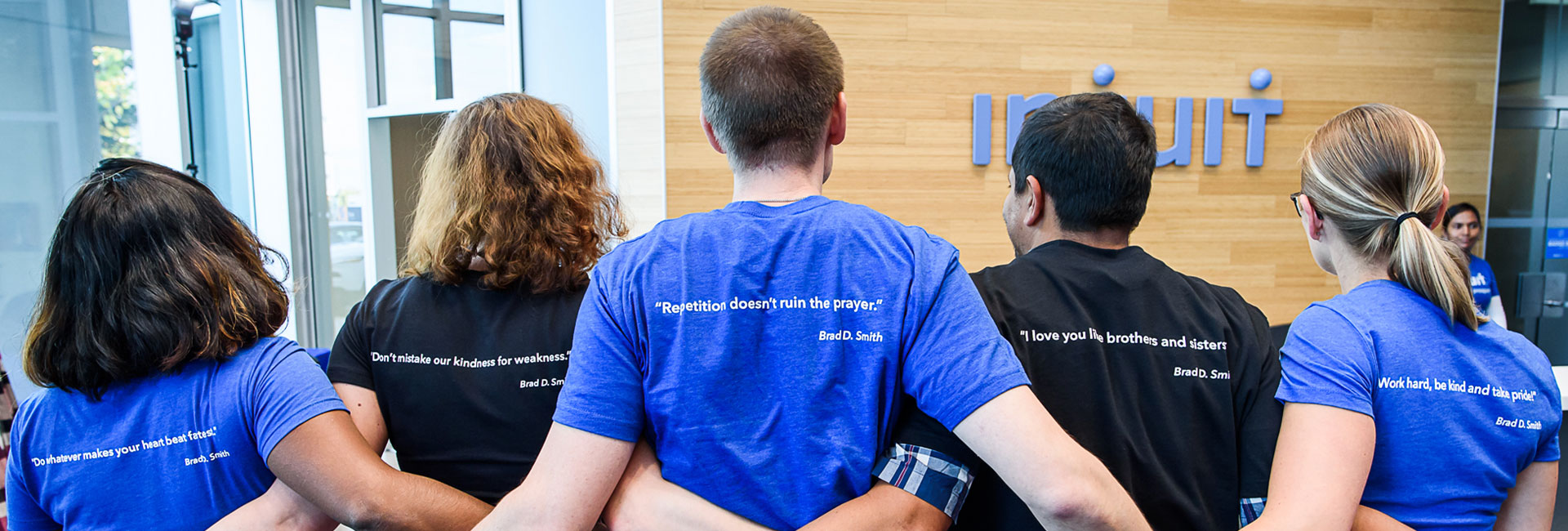 Employees wearing an Intuit shirt with Brad Smith quotes